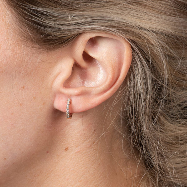 a close up of a woman's ear with a diamond ring