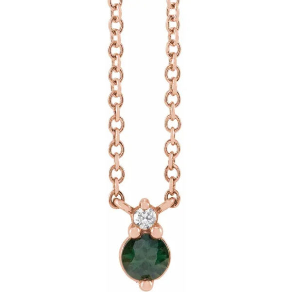 a necklace with a green stone and diamonds
