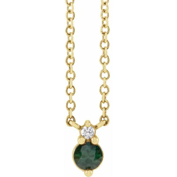a necklace with a green stone and a diamond