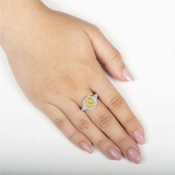 a woman's hand with a yellow and white diamond ring