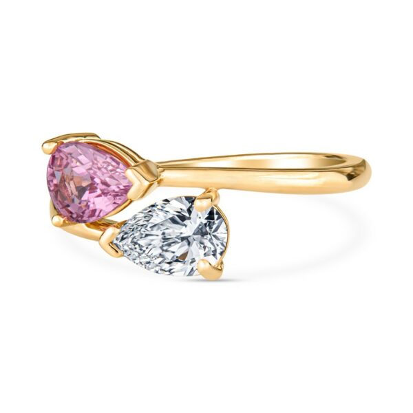 a pink and white diamond ring with two pear shaped diamonds
