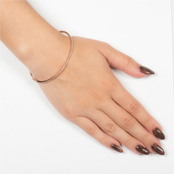 a woman's hand with brown nails and a bracelet