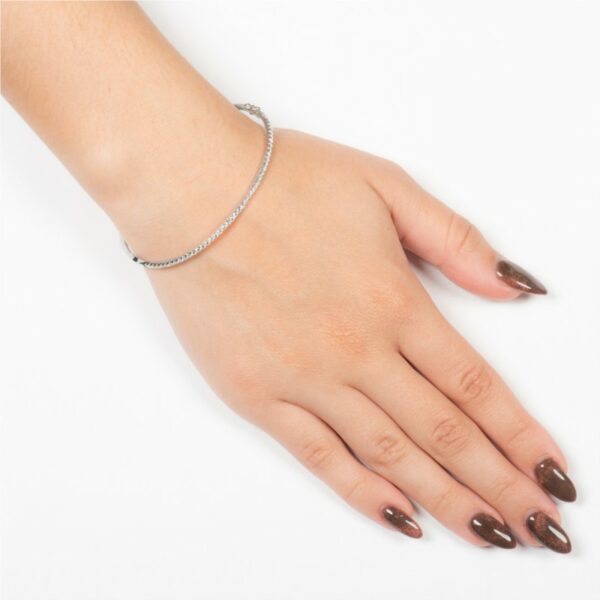 a woman's hand with brown nails and a bracelet