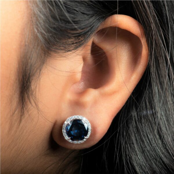 a woman's ear with a blue stone in the center
