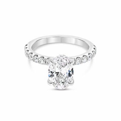 an oval cut diamond engagement ring on a white background