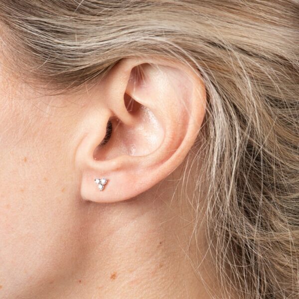 a woman's ear with a small diamond in the middle