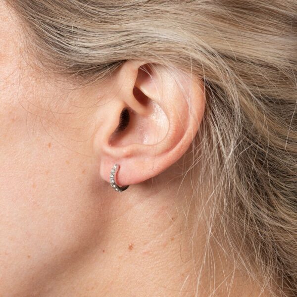 a woman's ear is shown with a small diamond in the middle