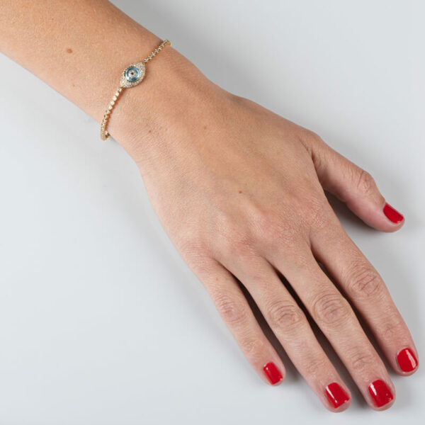 a woman's hand with red nail polish and a gold bracelet