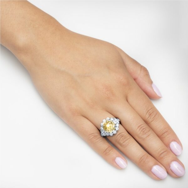 a woman's hand with a yellow and white diamond ring