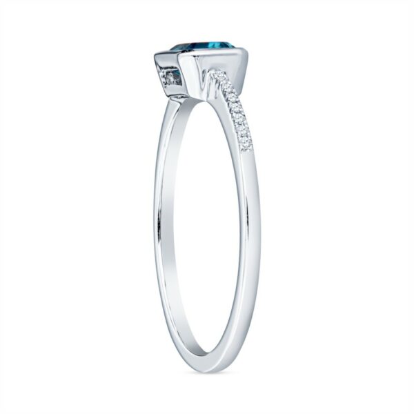 a white gold ring with an oval blue topaz