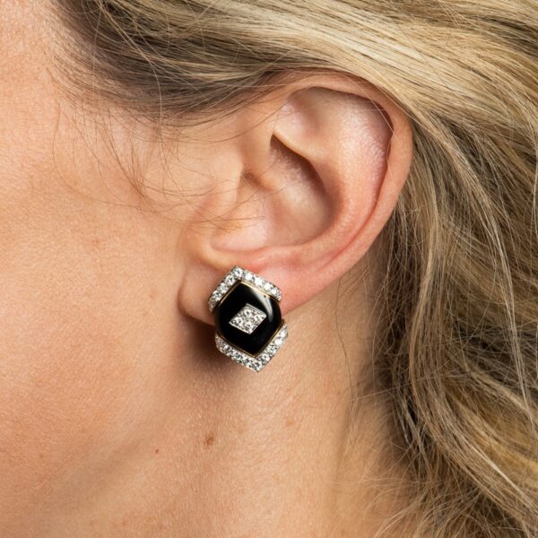 a close up of a woman's ear wearing a black and white earrings