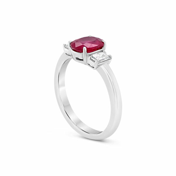 a white gold ring with a red stone and two diamonds