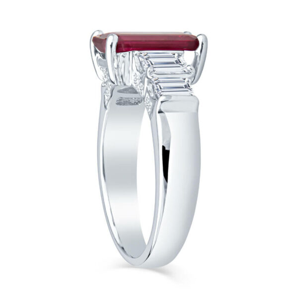 a white gold ring with a red stone