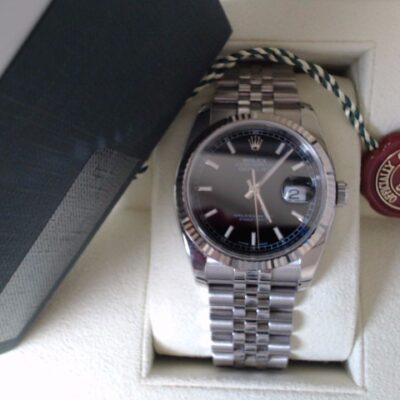 a rolex watch sitting on top of a box