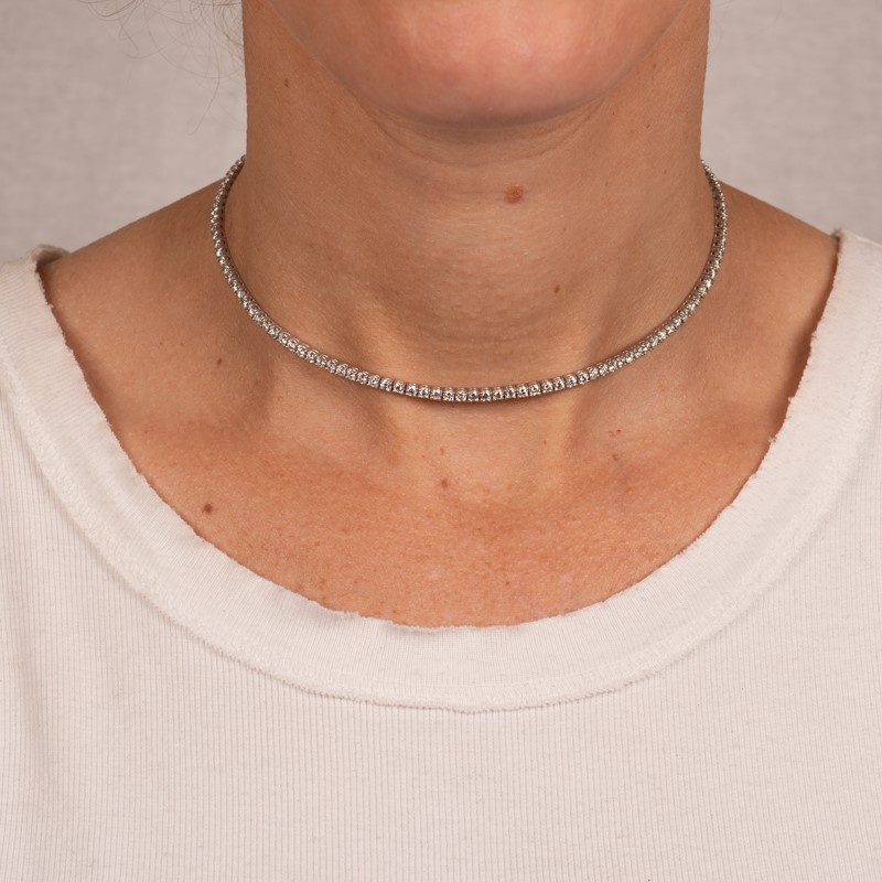 a woman wearing a silver necklace with beads