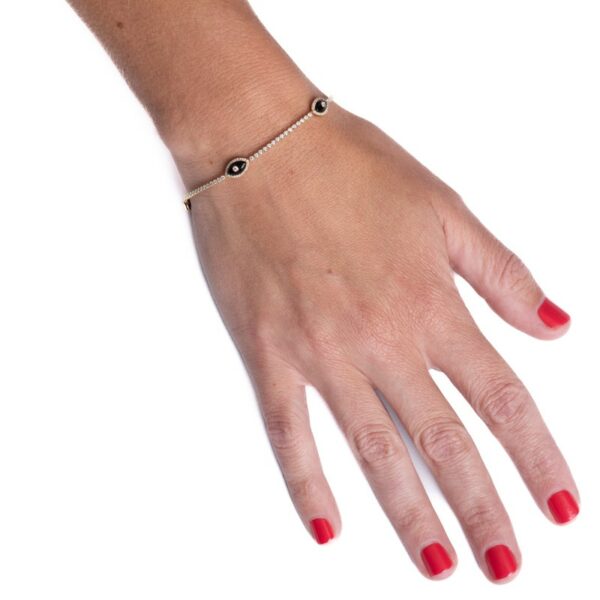 a woman's hand wearing a bracelet with an evil eye