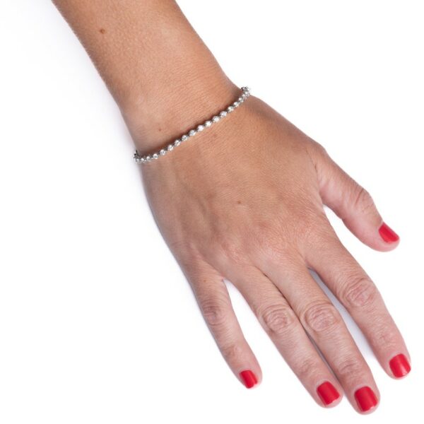 a woman's hand with red nails and a bracelet