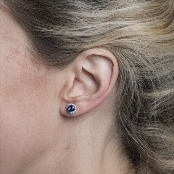 a woman with blonde hair wearing a pair of ear piercings