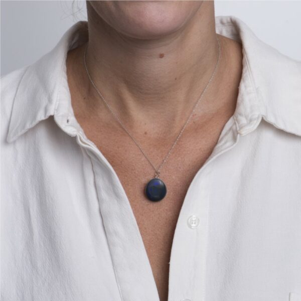 a woman wearing a white shirt and a blue necklace