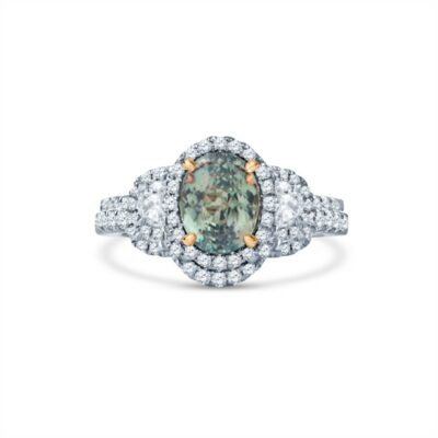 a fancy ring with an oval green diamond surrounded by white diamonds