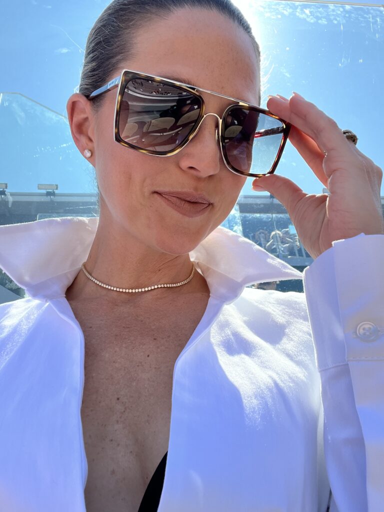 a woman wearing sunglasses and a white shirt
