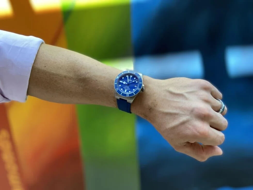 a man's wrist with a blue watch on it