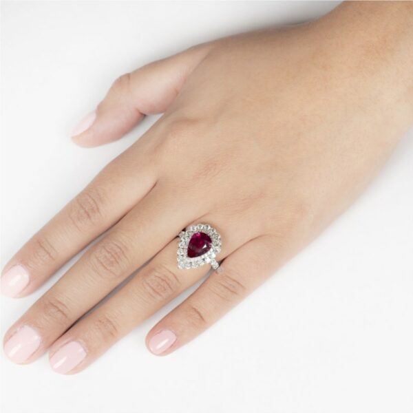 a woman's hand with a diamond and ruby ring