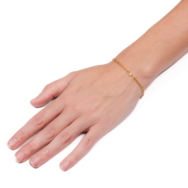 a woman's hand with a gold bracelet on it