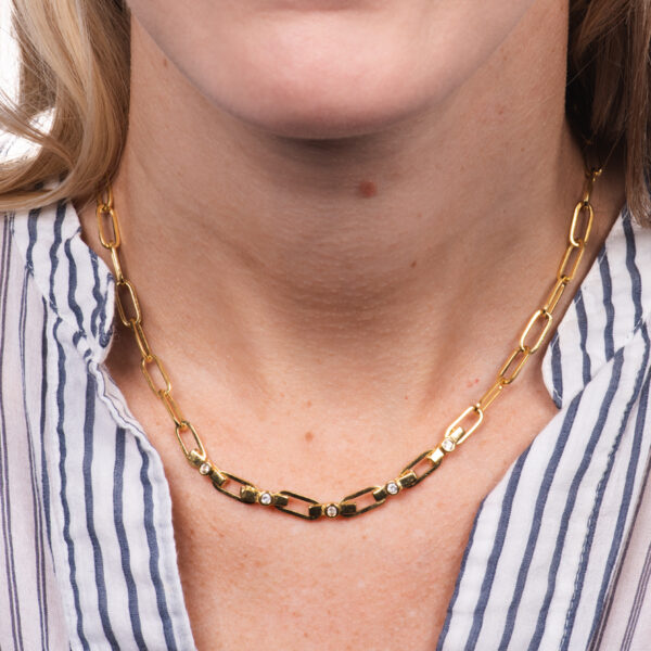 a woman wearing a striped shirt and a gold chain necklace