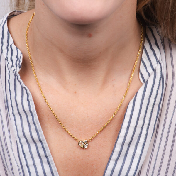 a woman wearing a striped shirt and a gold necklace