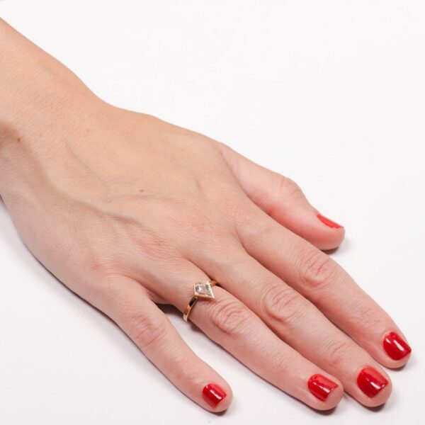 a woman's hand with red nail polish and a diamond ring