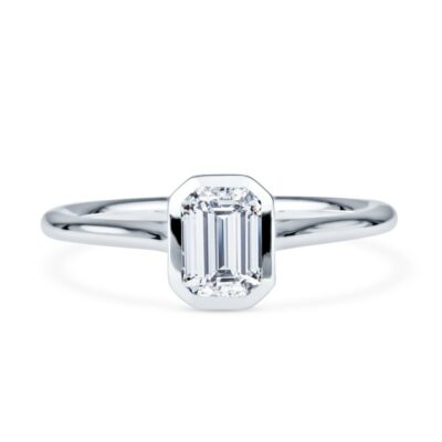 an emerald cut diamond ring on a white background
