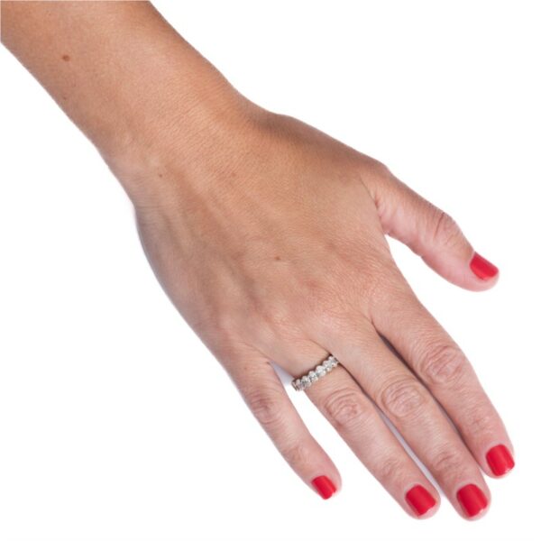 a woman's hand with red nails and a ring