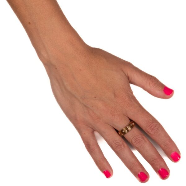 a woman's hand with pink nail polish and a gold ring
