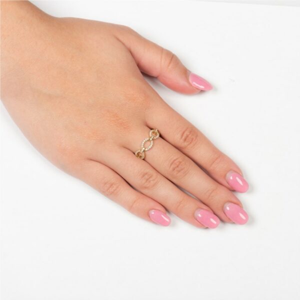 a woman's hand with pink manicured nails and a gold ring