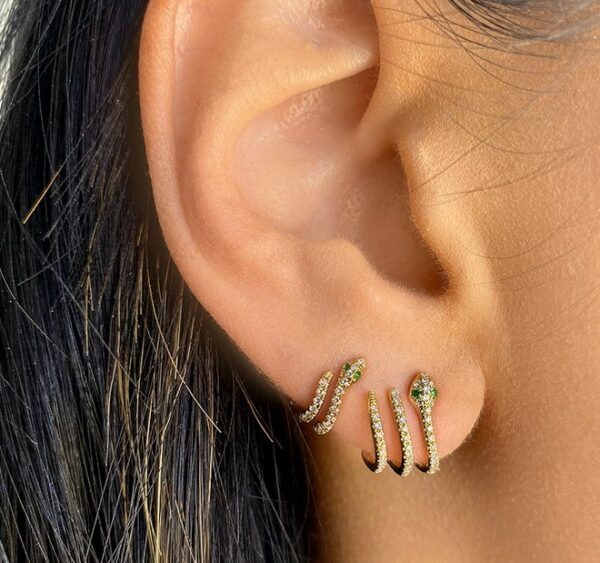 a close up of a person's ear with two different types of earrings on it