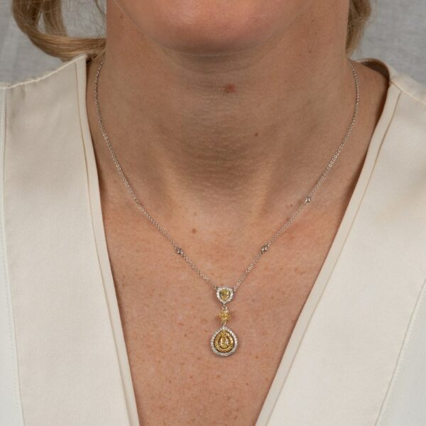 a woman wearing a necklace with a pendant on it