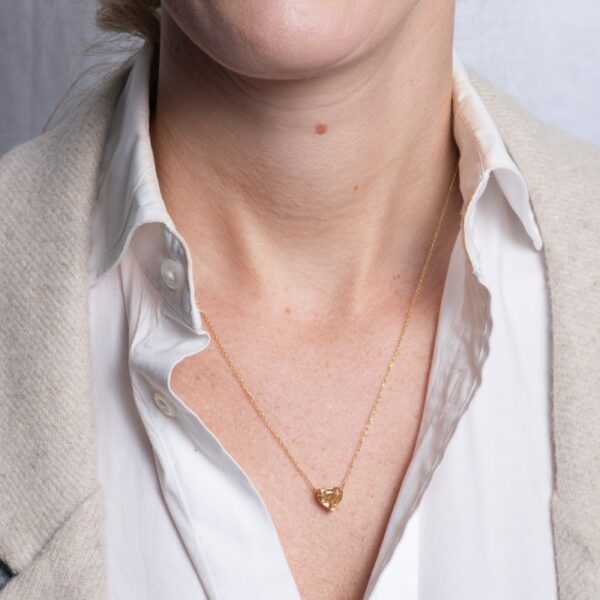 a woman wearing a white shirt and a gold necklace