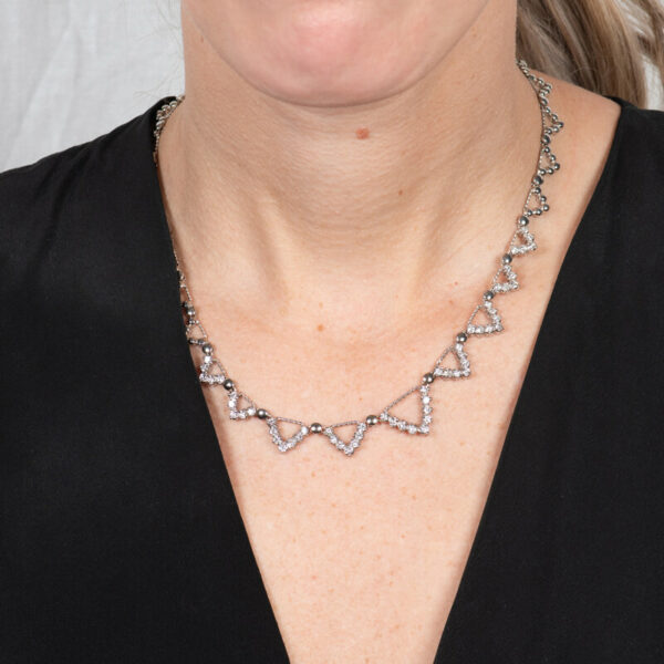 a woman wearing a necklace with hearts on it