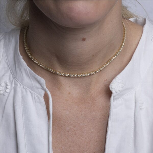 a woman wearing a white shirt and a gold chain necklace