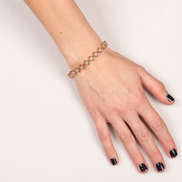 a woman's hand wearing a gold bracelet