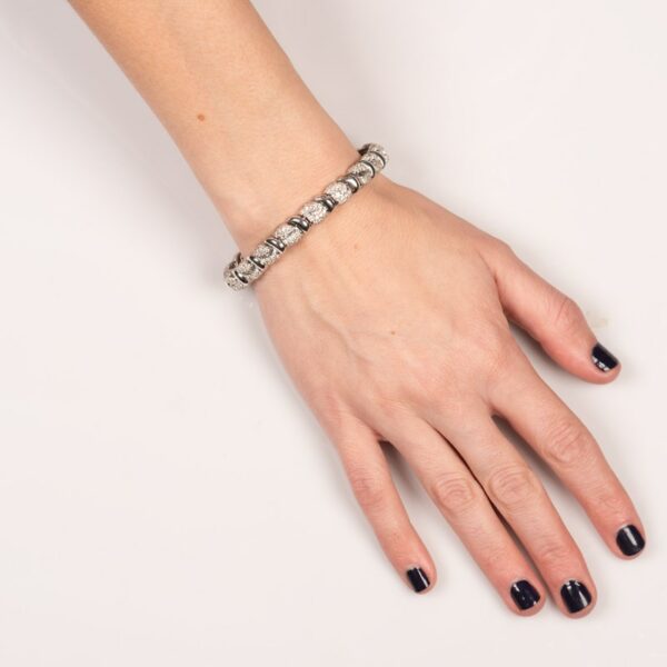 a woman's hand wearing a silver bracelet