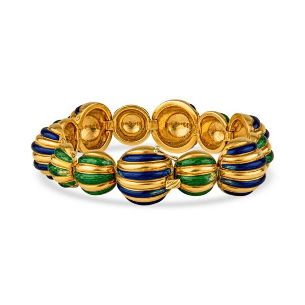 a gold bracelet with green and blue beads