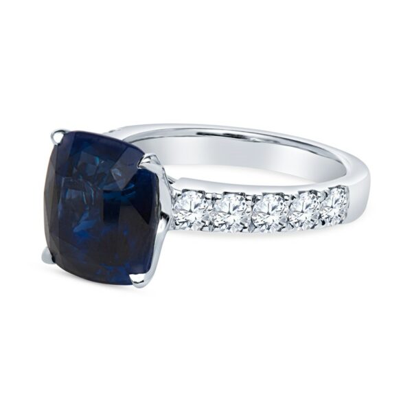 a ring with a cushion cut blue sapphire surrounded by diamonds