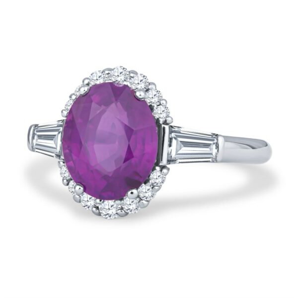 a ring with an oval shaped purple stone surrounded by baguetts