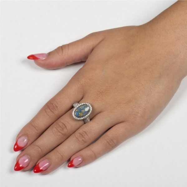 a woman's hand with red fingernails and a ring