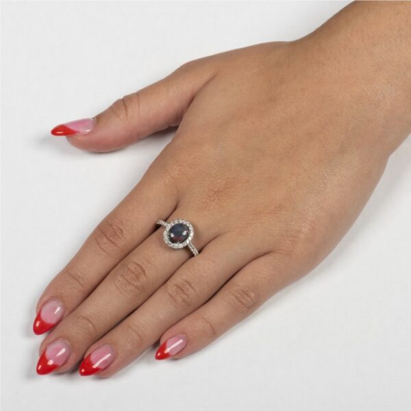 a woman's hand with red fingernails and a ring on it