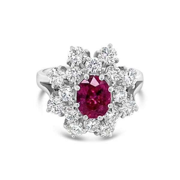 a ring with a red stone surrounded by white diamonds