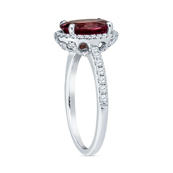 a ring with a red stone and diamonds on it