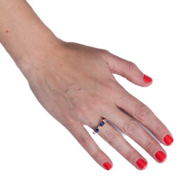 a woman's hand with red nails and a ring